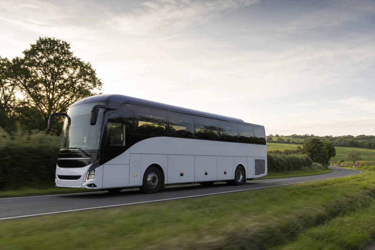 Autocar interurbain sur une route de campagne bretonne bordée de champs